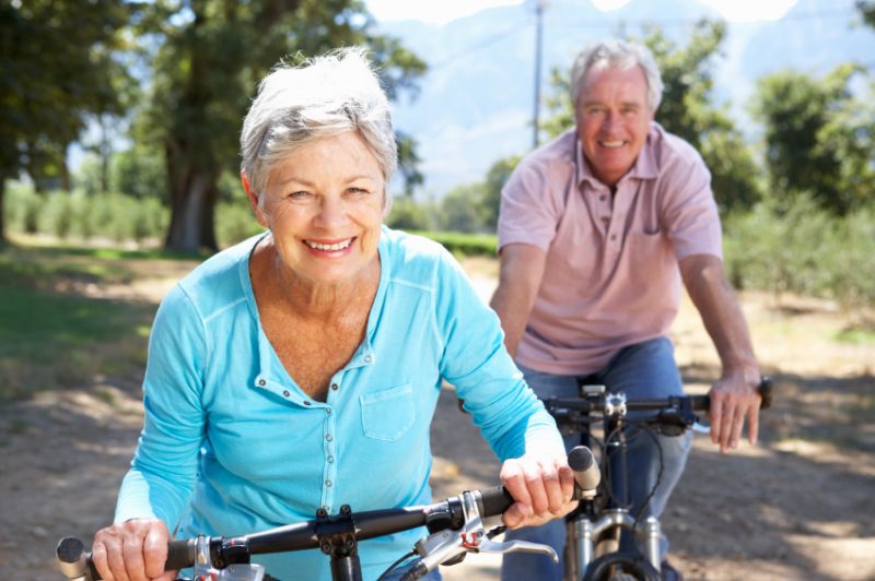 Senior man and woman riding a bike