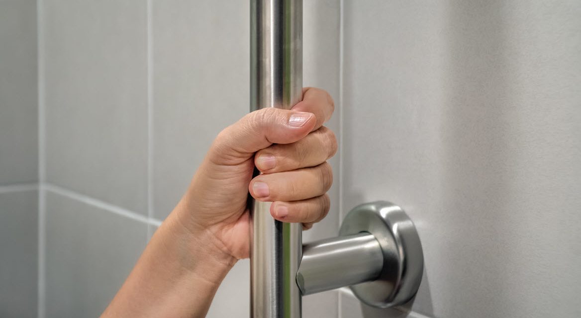 Hand holding onto a grab bar in the shower